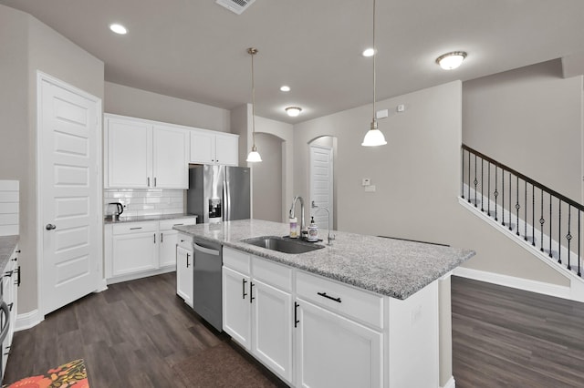 17052 Easter Lily Dr, Conroe, TX 77385 - kitchen featuring stainless steel appliances, a sink, arched walkways, dark wood finished floors, and recessed lighting