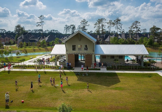 17052 Easter Lily Dr, Conroe, TX 77385 - back of property featuring metal roof, a water view, a residential view, and a lawn