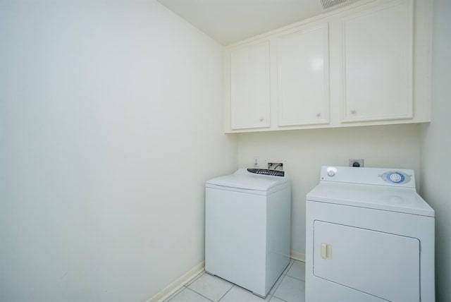 23006 Greenrush Dr, Katy, TX 77494 - clothes washing area with light tile patterned floors, visible vents, baseboards, cabinet space, and washing machine and clothes dryer