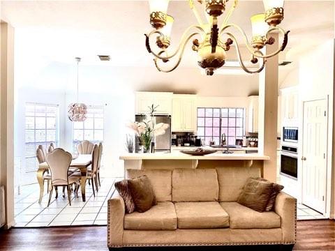 23006 Greenrush Dr, Katy, TX 77494 - living area with visible vents, an inviting chandelier, and dark wood-style floors