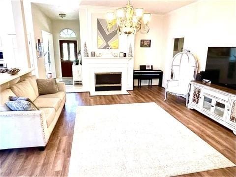 23006 Greenrush Dr, Katy, TX 77494 - living room featuring a chandelier, a fireplace with flush hearth, and wood finished floors
