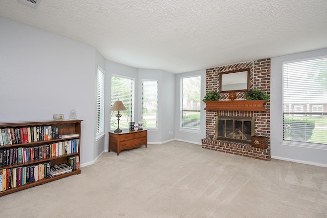 sitting room featuring a textured ceiling, a fireplace, baseboards, and carpet