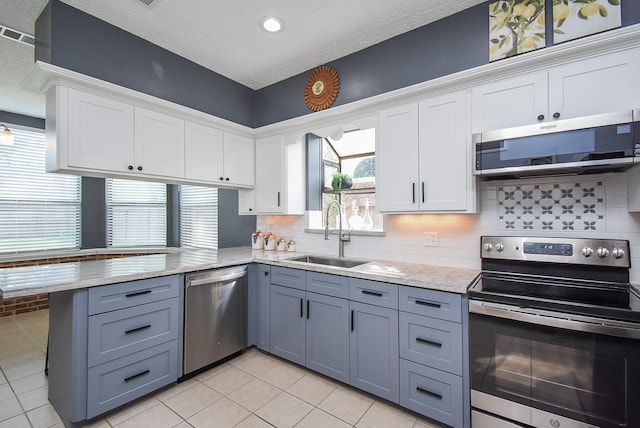 kitchen featuring a sink, appliances with stainless steel finishes, a peninsula, white cabinetry, and gray cabinets