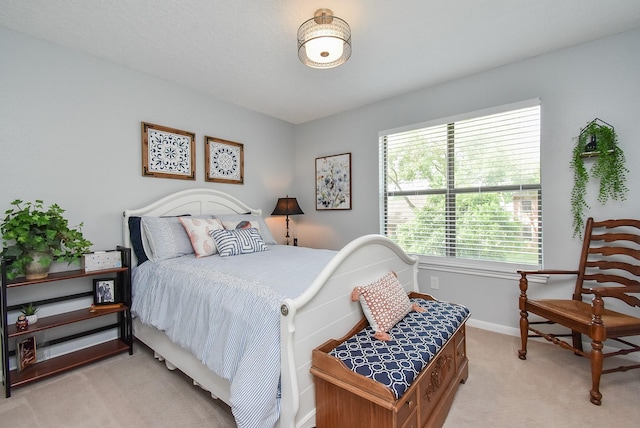 bedroom featuring light colored carpet and baseboards