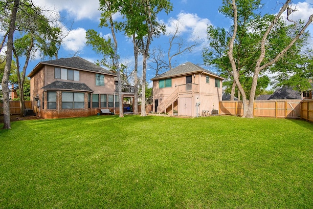 view of yard featuring stairway, a fenced backyard, and cooling unit