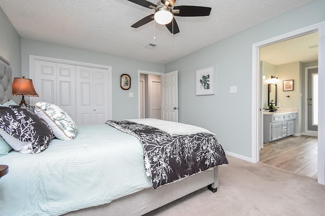 bedroom featuring baseboards, a closet, a textured ceiling, a ceiling fan, and light colored carpet