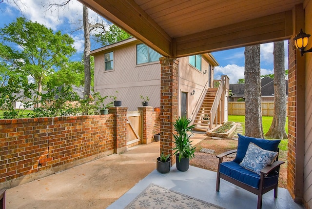 view of patio / terrace with a gate, fence, and stairs