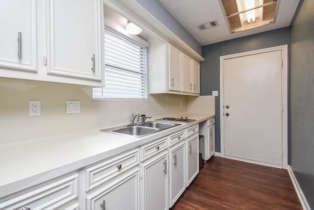 kitchen featuring white cabinetry, visible vents, dark wood-style flooring, light countertops, and a sink