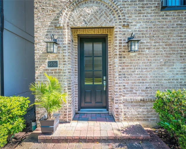 entrance to property featuring brick siding