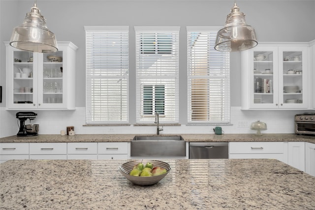 9506 London Bridge Sta, Houston, TX 77045 - kitchen featuring dishwasher, a sink, decorative backsplash, and white cabinetry