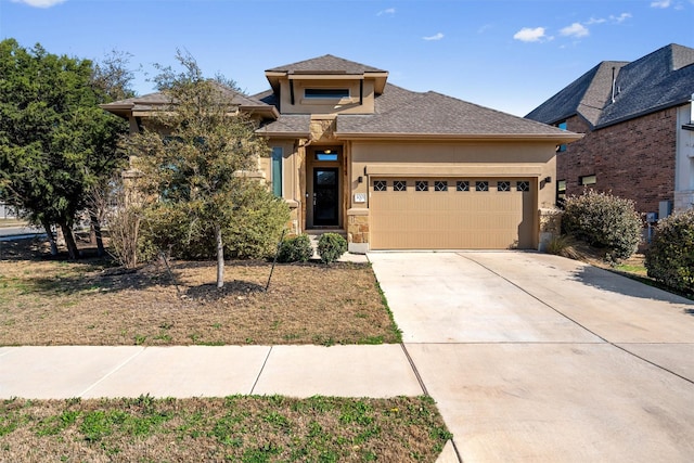 prairie-style home with a garage, stucco siding, and concrete driveway
