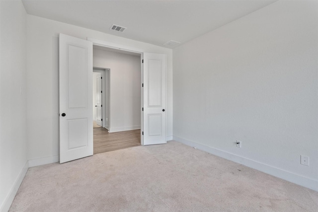 unfurnished room featuring visible vents, baseboards, and carpet