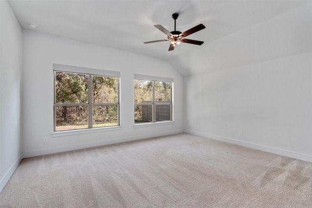 empty room with carpet floors, baseboards, a ceiling fan, and vaulted ceiling