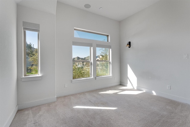 spare room with baseboards and carpet floors