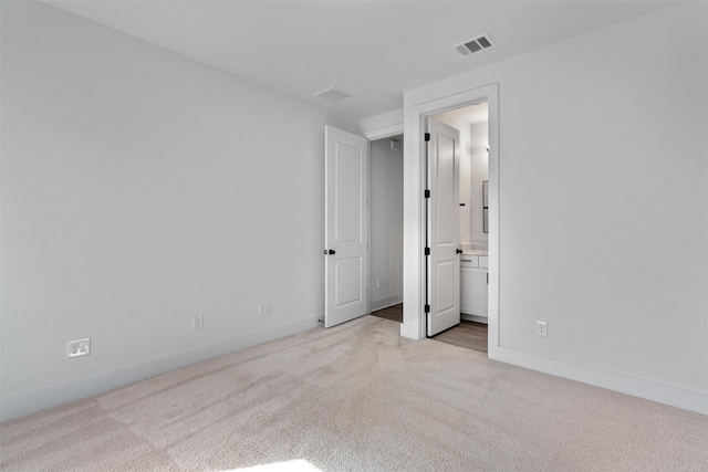 carpeted spare room featuring baseboards and visible vents