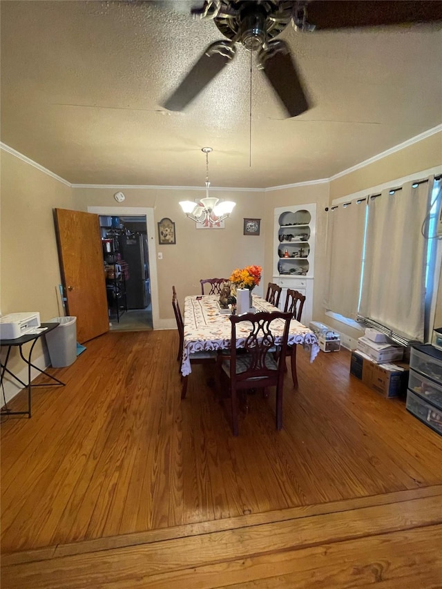 406 W Liberty Rd, Harleton, TX 75651 - dining space with ceiling fan with notable chandelier, wood finished floors, built in shelves, and crown molding