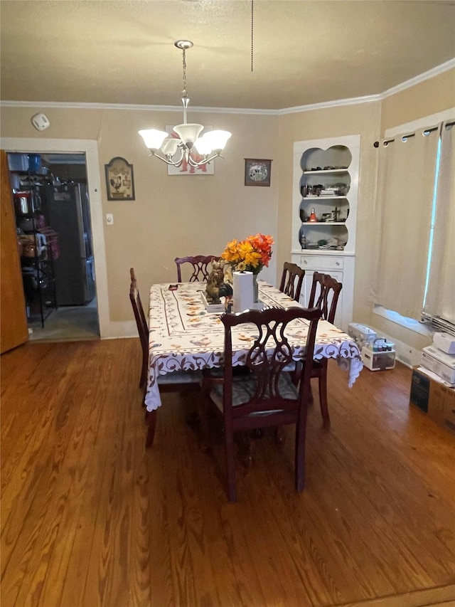 406 W Liberty Rd, Harleton, TX 75651 - dining space featuring wood finished floors, crown molding, a notable chandelier, and built in features