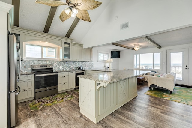 kitchen featuring open floor plan, visible vents, a ceiling fan, and appliances with stainless steel finishes