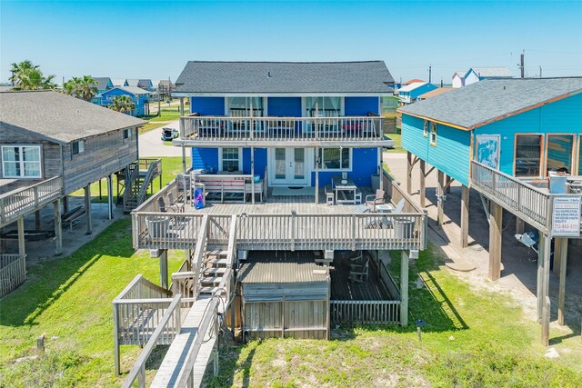 1654 Sandpebble Pl, Surfside Beach, TX 77541 - back of house with a deck, stairway, a shingled roof, a lawn, and a hot tub