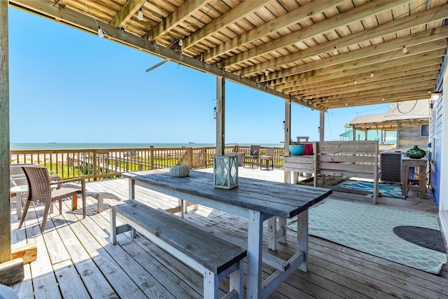 wooden deck with a water view and a view of the beach
