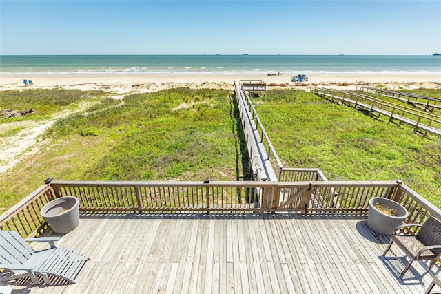 wooden deck featuring a water view and a beach view