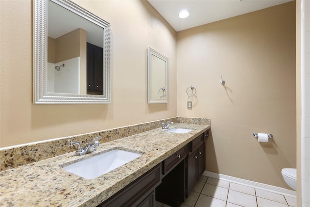 2327 Brookdale Dr, Kingwood, TX 77339 - bathroom with toilet, double vanity, tile patterned flooring, and baseboards