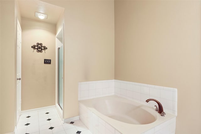 2327 Brookdale Dr, Kingwood, TX 77339 - bathroom featuring a bath, tile patterned flooring, a shower stall, and baseboards