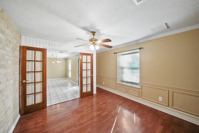 2327 Brookdale Dr, Kingwood, TX 77339 - spare room featuring french doors, plenty of natural light, wood finished floors, a textured ceiling, and a chandelier