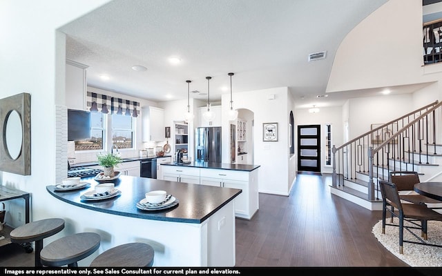13724 Seneca Lake Dr, Texas City, TX 77568 - kitchen with visible vents, arched walkways, dark countertops, appliances with stainless steel finishes, and a peninsula