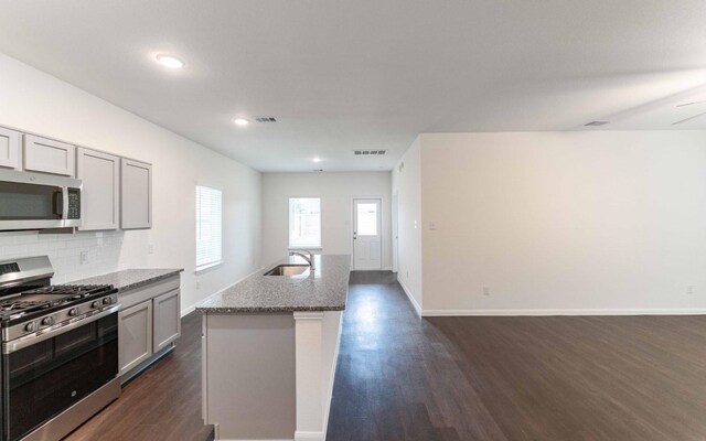 3109 Aqua Wave Dr, Texas City, TX 77568 - kitchen with stainless steel appliances, a sink, dark wood-style floors, light stone countertops, and backsplash