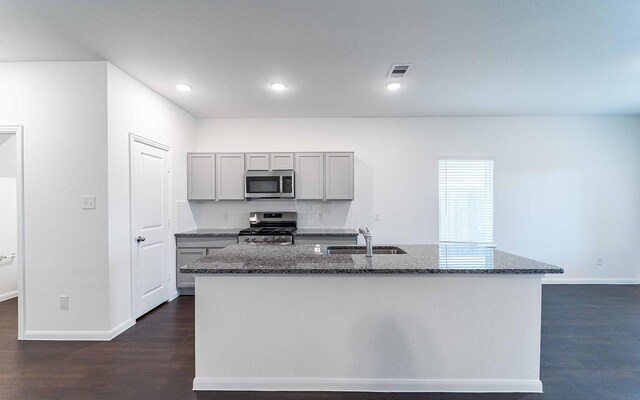 3109 Aqua Wave Dr, Texas City, TX 77568 - kitchen with appliances with stainless steel finishes, a sink, gray cabinetry, dark stone countertops, and dark wood-type flooring
