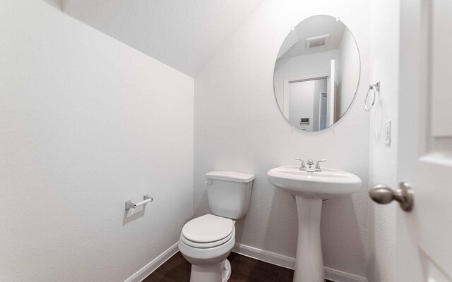 3109 Aqua Wave Dr, Texas City, TX 77568 - bathroom featuring toilet, wood finished floors, baseboards, a sink, and lofted ceiling