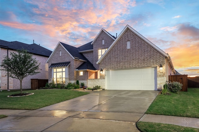 view of front of property with fence, driveway, a lawn, brick siding, and a garage