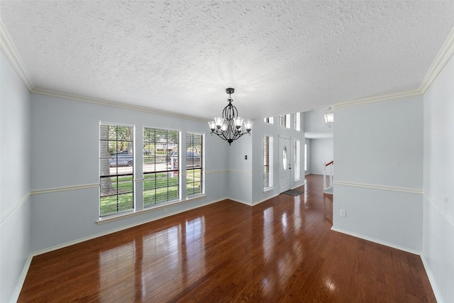 unfurnished dining area featuring wood-type flooring, baseboards, a notable chandelier, and a textured ceiling