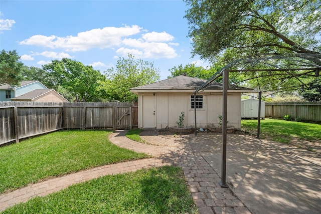 view of yard featuring a storage unit, an outbuilding, a fenced backyard, and a patio