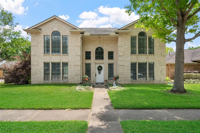view of front of home with brick siding and a front yard