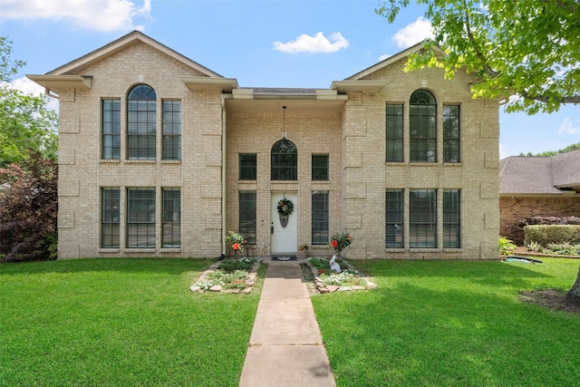 view of front of home featuring brick siding and a front lawn