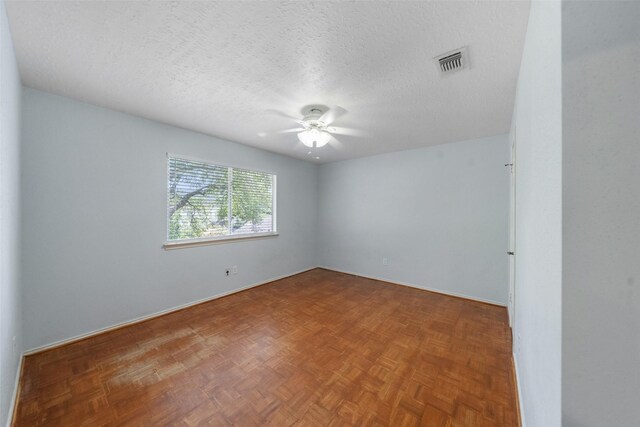 unfurnished room featuring ceiling fan, baseboards, a textured ceiling, and visible vents