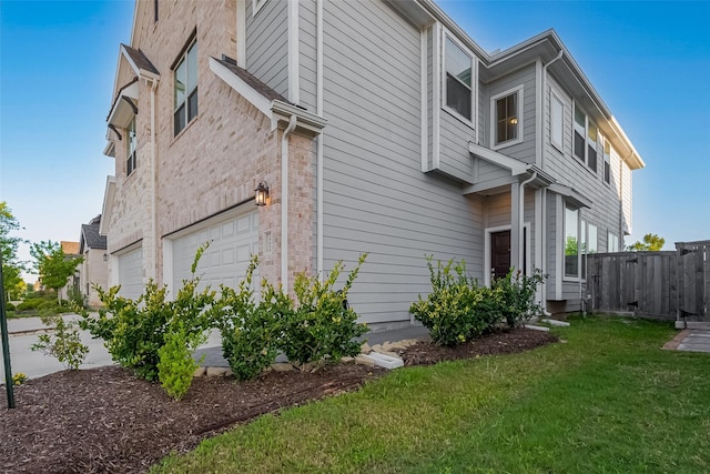 view of home's exterior with brick siding and a lawn