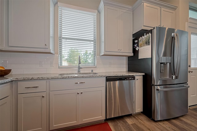 kitchen with dark wood-type flooring, tasteful backsplash, white cabinetry, appliances with stainless steel finishes, and a sink
