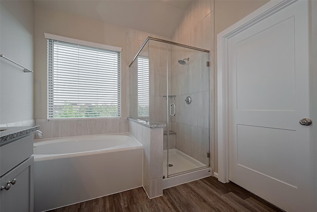 bathroom featuring a bath, wood finished floors, and a stall shower
