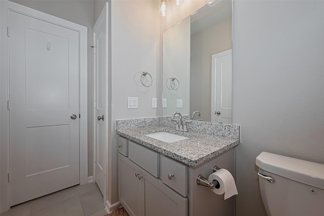 half bathroom featuring tile patterned flooring, toilet, and vanity
