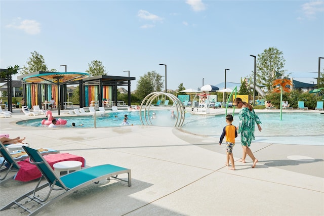 community pool with a water play area and a patio area