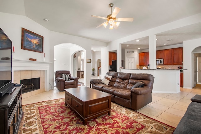 12506 Opal Valley Dr, Tomball, TX 77377 - living room with light tile patterned floors, ceiling fan, arched walkways, recessed lighting, and a tiled fireplace