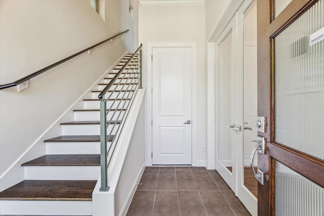 interior space with crown molding, tile patterned flooring, and baseboards