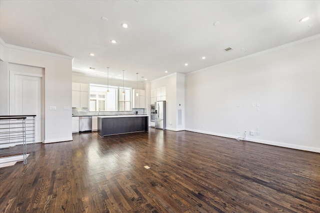 unfurnished living room featuring dark wood finished floors, ornamental molding, and recessed lighting