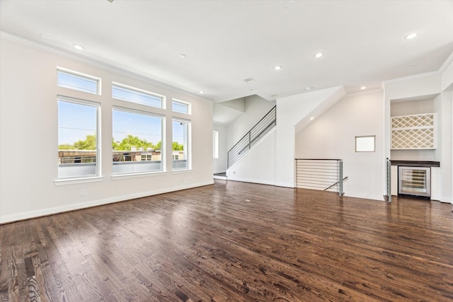 unfurnished living room with crown molding, beverage cooler, wood finished floors, and recessed lighting
