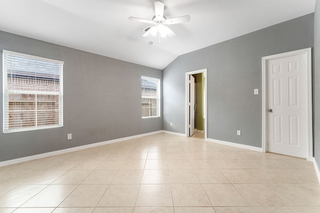 empty room featuring light tile patterned floors, baseboards, a ceiling fan, and lofted ceiling