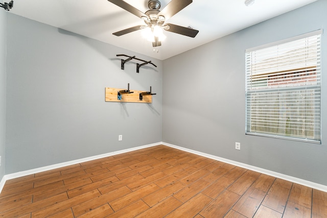 unfurnished room with ceiling fan, baseboards, and wood finished floors