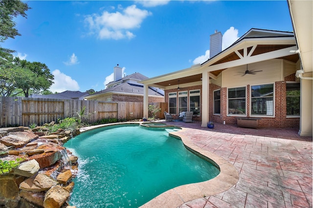 view of pool featuring a fenced backyard, a pool with connected hot tub, a patio, and ceiling fan